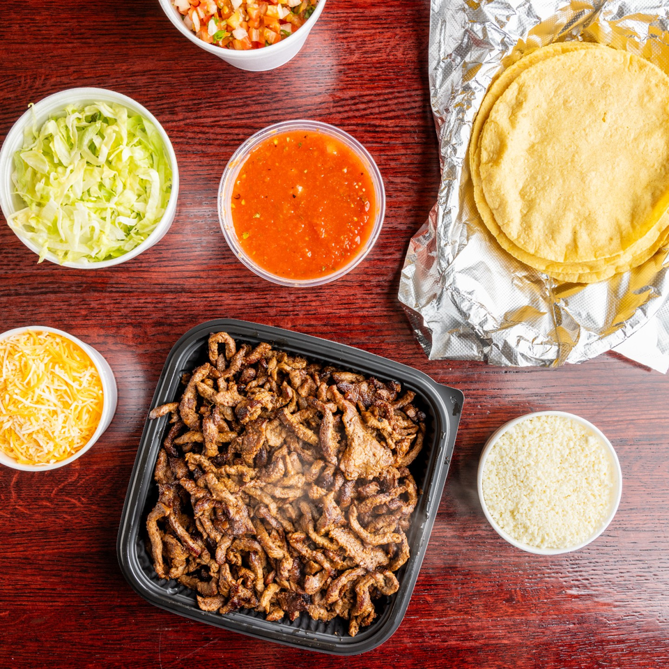 Nally's taco spread with tortillas, meat, salsa, and toppings.